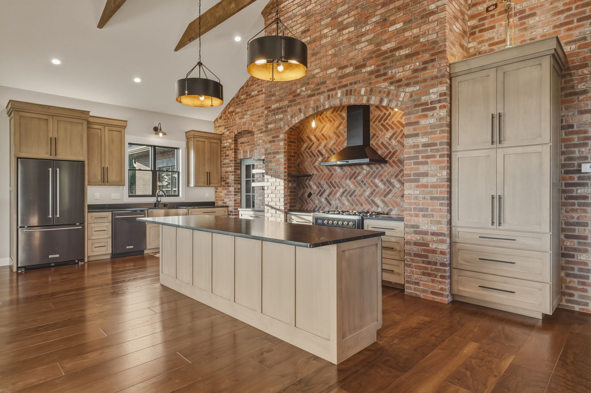 Kitchen island with brick herringbone range hood