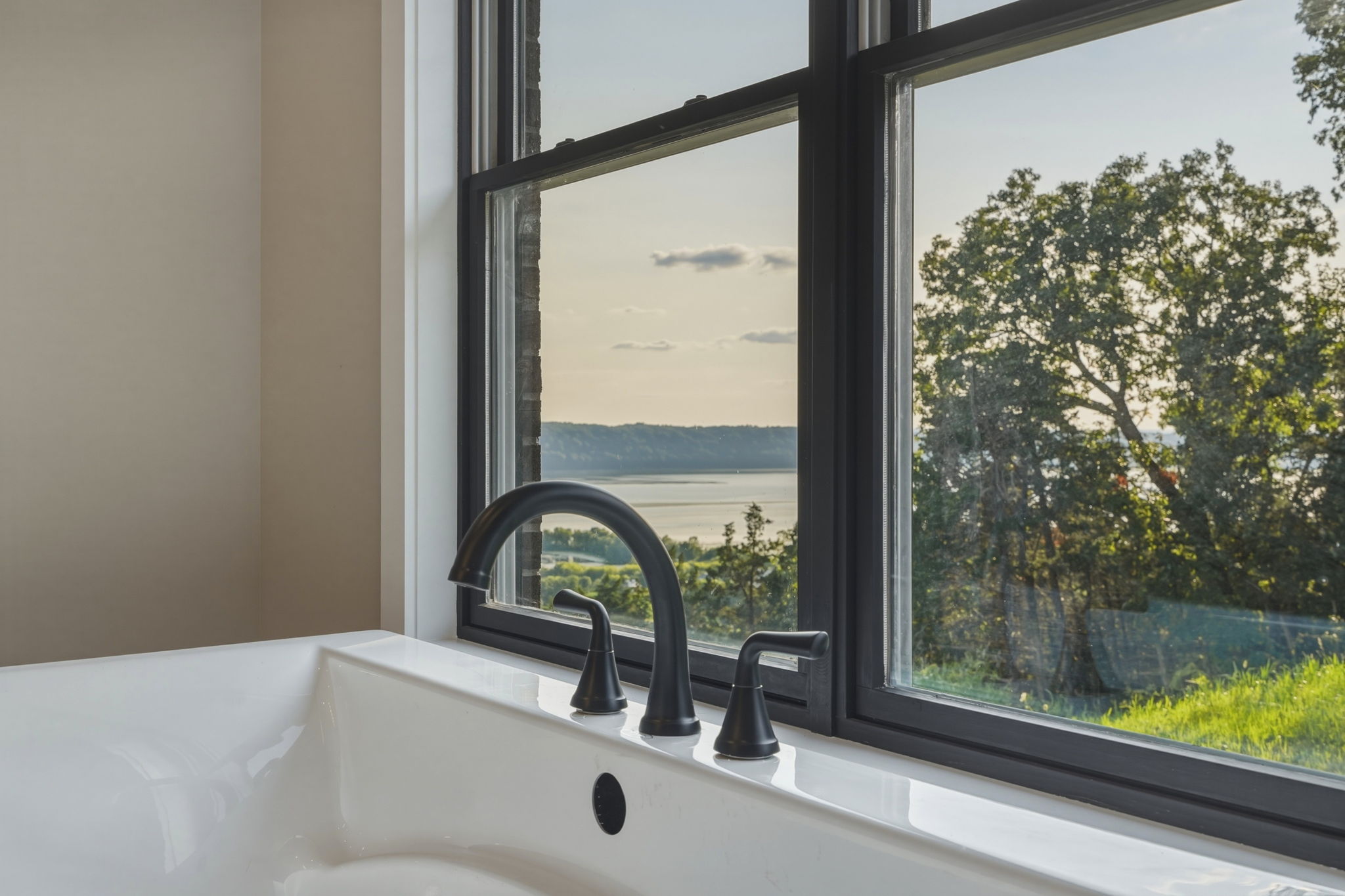 Primary bath soaking tub set in a window nook overlooking the valley